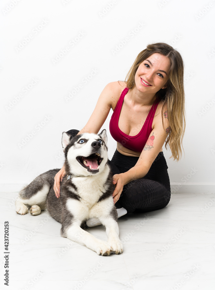 Young sport girl with her dog sitting on the floor Young sport girl with her dog sitting on the floor