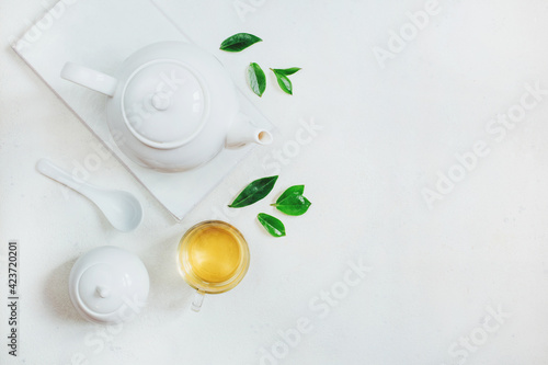 top view of a set of tea utensils teapot sugar bowl cup with tea on a white background