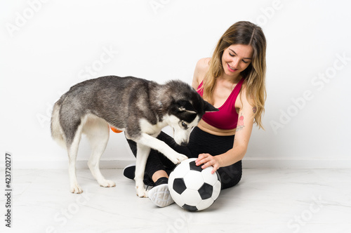 Young sport girl with her dog sitting on the floor