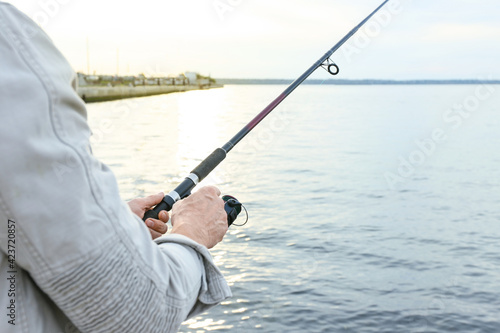 Man fishing on river bank, closeup