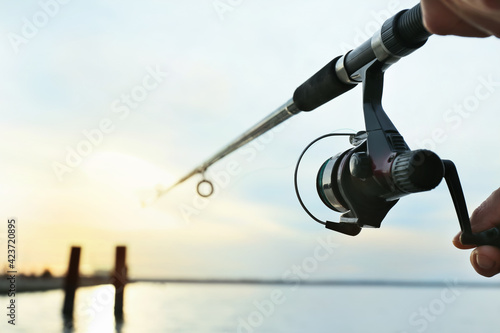 Man fishing on river bank, closeup