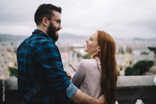 Back view of cheerful male and female tourists discussing conversation and laughing during leisure time, happy Caucasian couple in love enjoying live talking during getaway travelling on vacations