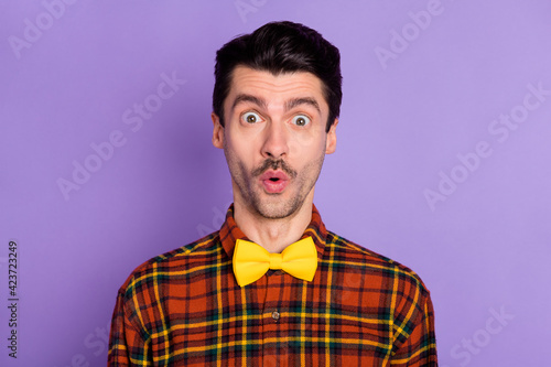 Portrait of attractive amazed brunet funky guy wearing checked shirt pout lips isolated over violet purple color background
