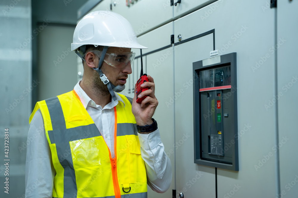 Electrician operator on the job during close circuit breaker in switchgear room of a power plant. Electrician operator on the job during close circuit breaker in switchgear room of a power plant.