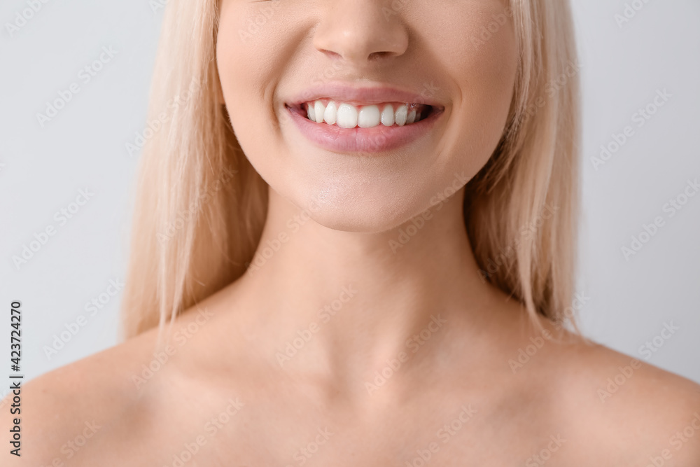 Beautiful smiling young woman on light background, closeup Beautiful smiling young woman on light background, closeup