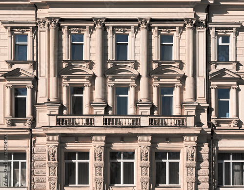 Beautiful old classical facade of the building. Windows with balcony, columns and moldings