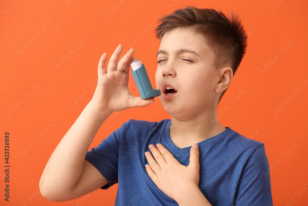 Little boy with inhaler having asthma attack on color background Little boy with inhaler having asthma attack on color background