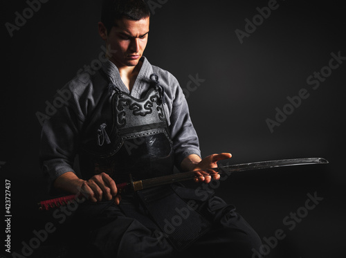 Portrait of Kendo master sitting and preparing for fight.