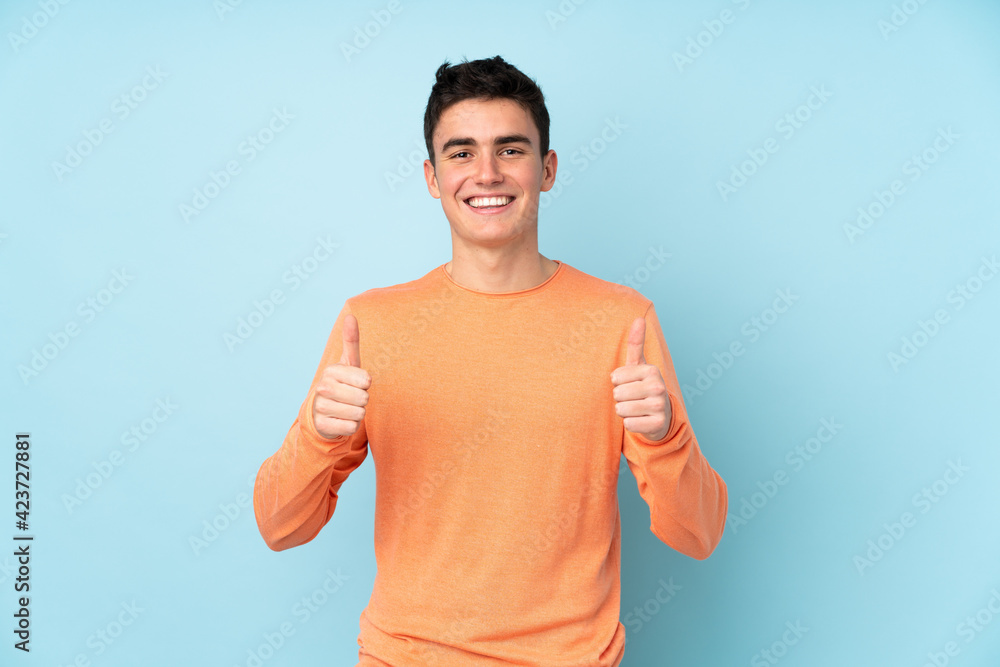 Teenager caucasian handsome man isolated on purple background giving a thumbs up gesture Teenager caucasian handsome man isolated on purple background giving a thumbs up gesture