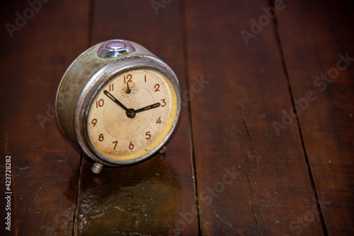 Old and retro alarm clock on wooden surface