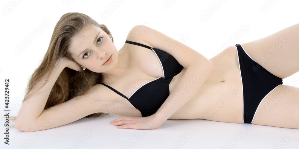 © Dan Race - Pretty slim teenage girl wearing a black bikini in studio isolated on white © Dan Race - Pretty slim teenage girl wearing a black bikini in studio isolated on white