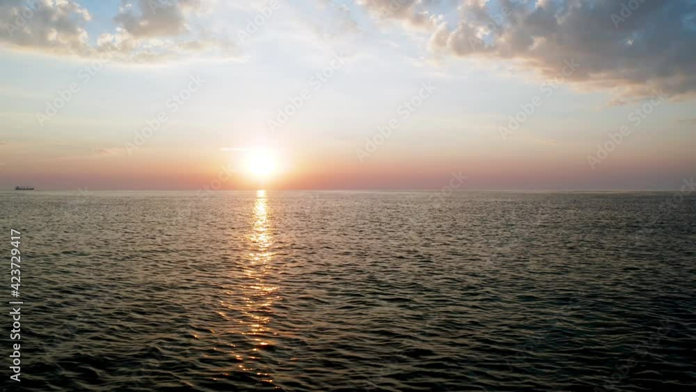 Aerial video over morning calm sea and beautiful sunrise with reflections.