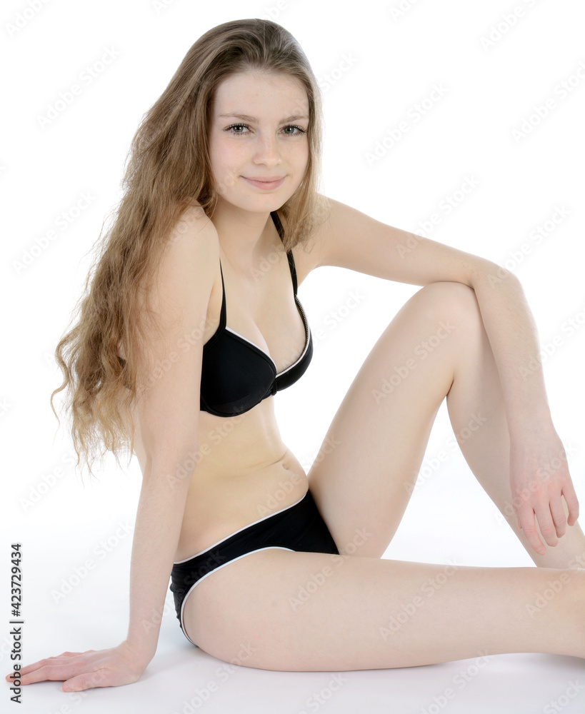 Gorgeous teenage girl wearing a black bikini in studio isolated on white  Stock Photo | Adobe Stock
