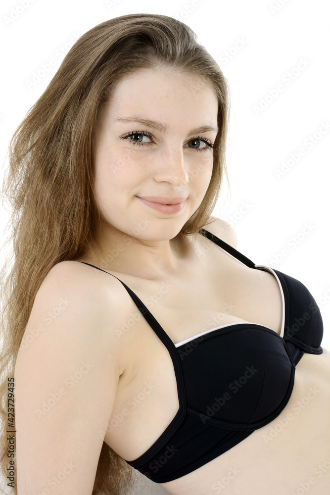 Happy smiling teenage girl wearing a black bikini in studio isolated on white Happy smiling teenage girl wearing a black bikini in studio isolated on white