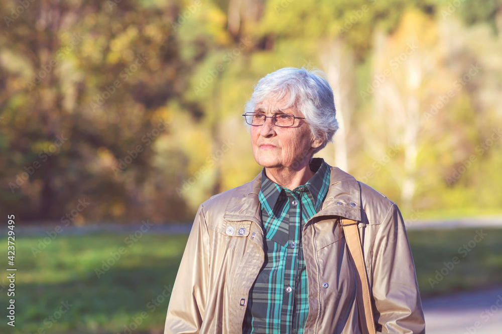 Senior Woman Walking in the Autumn Park Senior Woman Walking in the Autumn Park