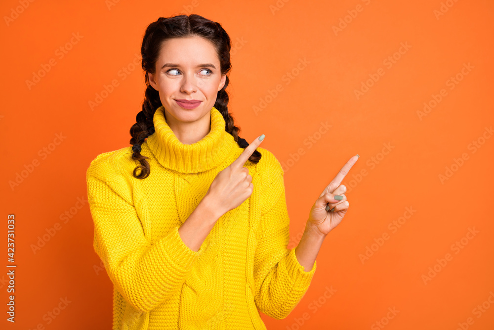 Portrait of charming lady look indicate two hands fingers empty space isolated on orange color background Portrait of charming lady look indicate two hands fingers empty space isolated on orange color background
