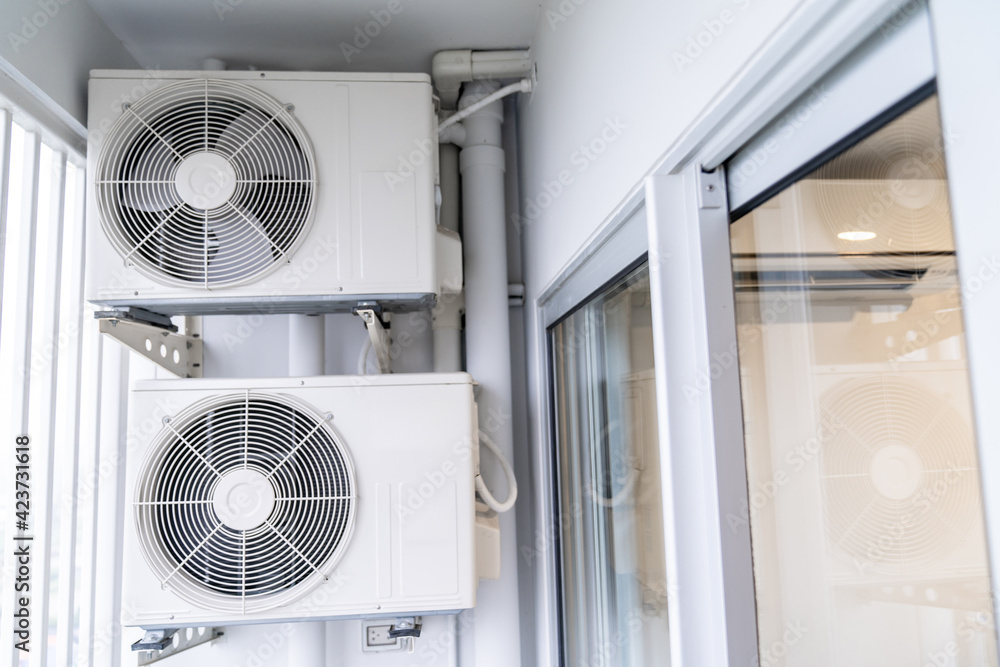 two air conditioning compressors are hung on wall. two air conditioning compressors are hung on wall.