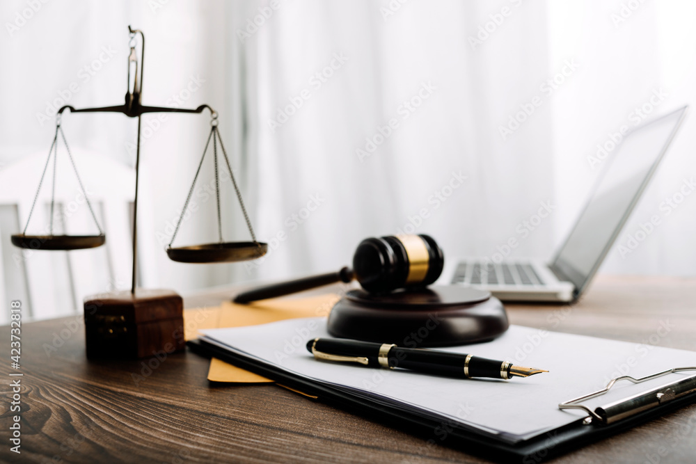 Business and lawyers discussing contract papers with brass scale on desk in office. Law, legal services, advice, justice and law concept picture with film grain effect Business and lawyers discussing contract papers with brass scale on desk in office. Law, legal services, advice, justice and law concept picture with film grain effect