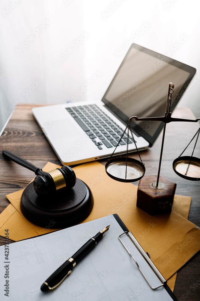Business and lawyers discussing contract papers with brass scale on desk in office. Law, legal services, advice, justice and law concept picture with film grain effect Business and lawyers discussing contract papers with brass scale on desk in office. Law, legal services, advice, justice and law concept picture with film grain effect