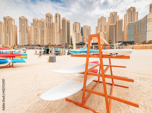 Photography Stand with surf and sup boards for rent and swimming in the sea at JBR Beach in Dubai