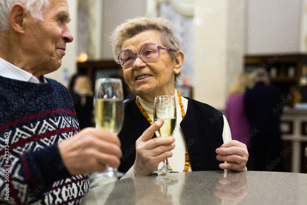 Senor and senora walking and drinking champagne in hall of cafeteria