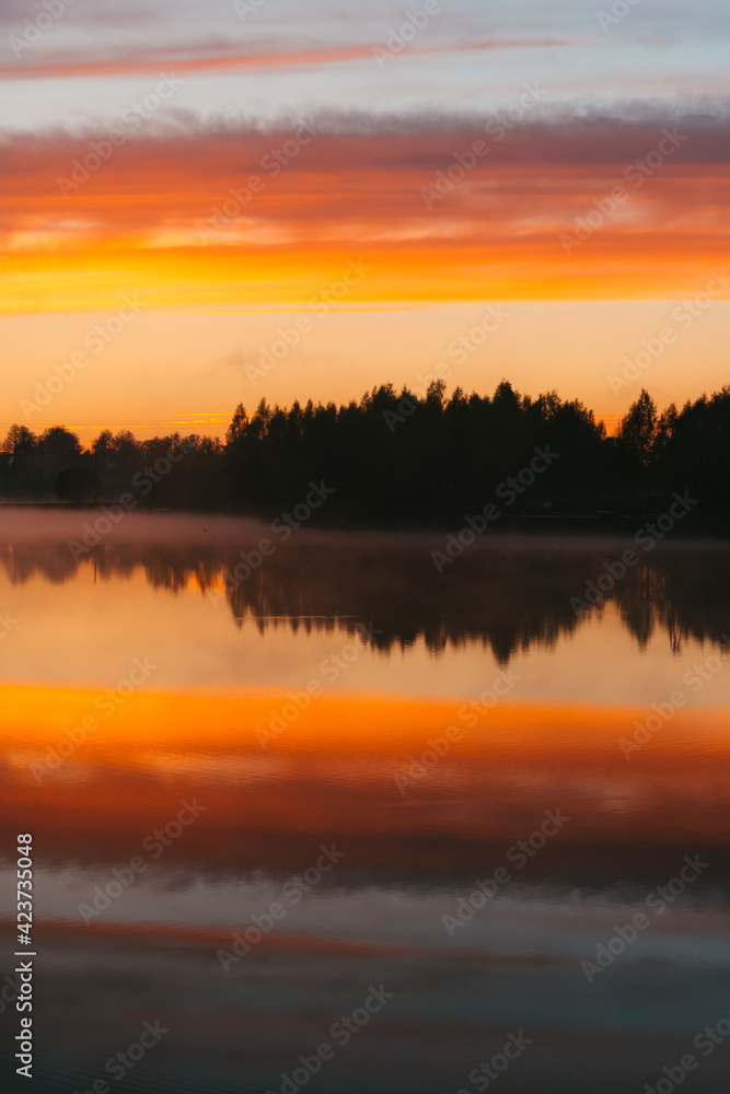 Colorful sunset over the Lielais Ansis lake in Latvia. Sunset reflections in the water Colorful sunset over the Lielais Ansis lake in Latvia. Sunset reflections in the water