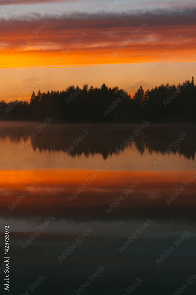 Colorful sunset over the Lielais Ansis lake in Latvia. Sunset reflections in the water
