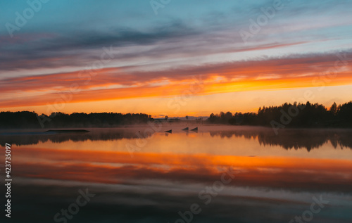 Colorful sunset over the Lielais Ansis lake in Latvia. Sunset reflections in the water over the wakeboard park © Janis Eglins
