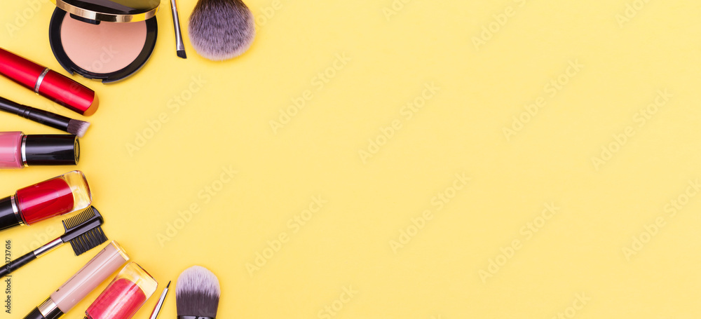 Make up the essentials. A set of professional makeup brushes and cosmetics on a yellow background. - obrazy, fototapety, plakaty 