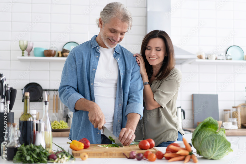 Couple cooking together in their kitchen at home.