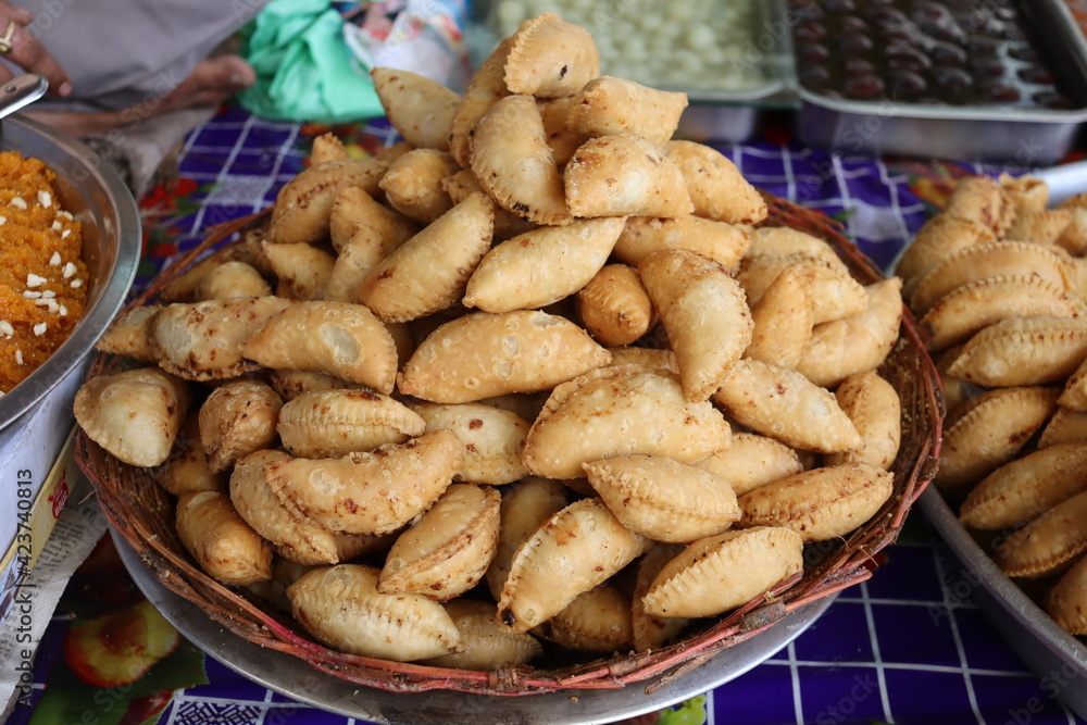 A basket full of fresh Indian snacks- Gujiya prepared during the festival of Colors. Holi is celebrated by eating delicious food. A basket full of fresh Indian snacks- Gujiya prepared during the festival of Colors. Holi is celebrated by eating delicious food.
