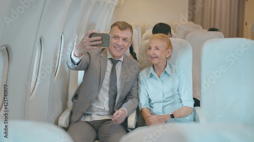 Happy Adult Caucasian passengers is making selfie or Video call onboard   travel vacation and transportation concept..