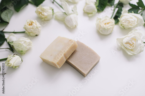 Handmade natural floral soap and roses on white background. Soap making. Soap bars. Spa, skin care. Natural Organic spa cosmetics on white table from above. flat lay, top view