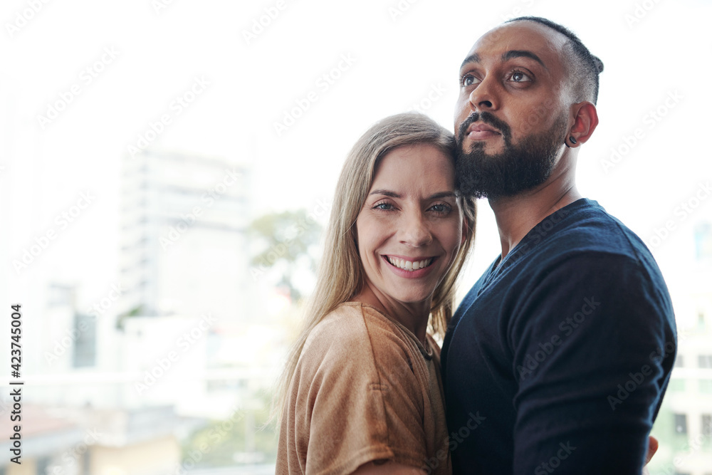 Cheerful mixed-race couple in love hugging when standing outdoors Cheerful mixed-race couple in love hugging when standing outdoors