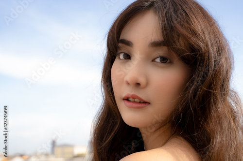Close up face of young Asian woman looking at camera