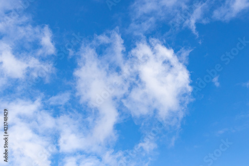 Detail of a white cloud in a bright blue sky.  Dark rain clouds displace the blue sky. Storm is coming. Cumulus clouds on a sunny Day. 
