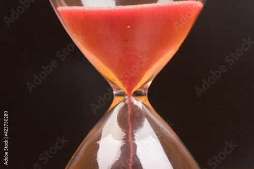 Crystal hourglass on black background as a concept of passing time for business term, urgency and outcome of time.