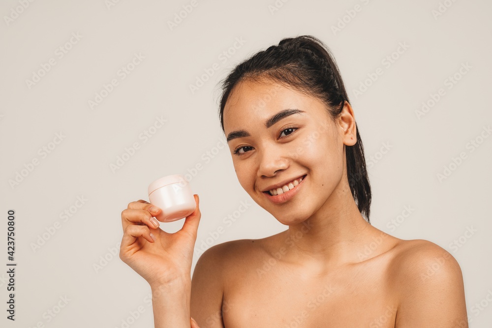Portrait of natural young woman, holds nutrition face cream. Isolated over white background. Natural beauty and health Portrait of natural young woman, holds nutrition face cream. Isolated over white background. Natural beauty and health