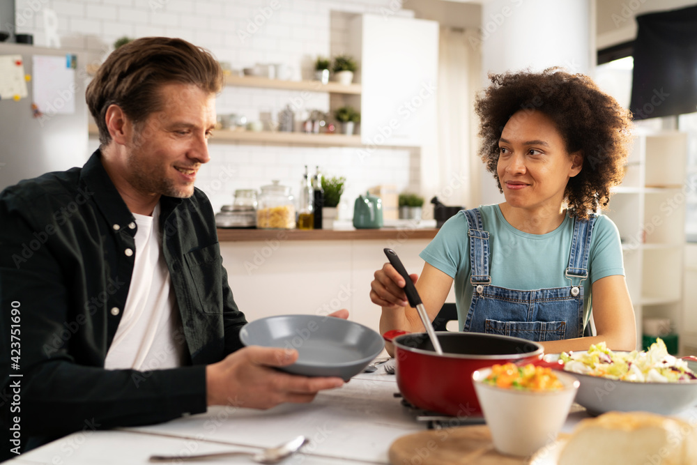 Loving couple eating lunch together at home. Husband and wife enjoying in tasty meal. Loving couple eating lunch together at home. Husband and wife enjoying in tasty meal.