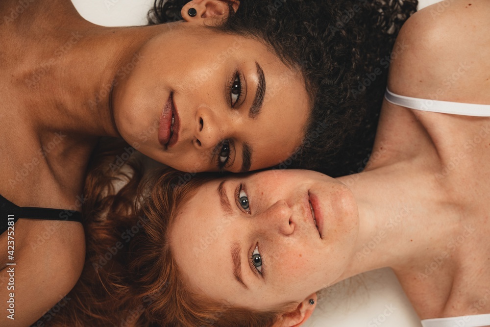 Fototapeta premium Photo of natural multiracial women, body positive. Feminist females lay down, isolated on white background. Concept natural beauty and girl power