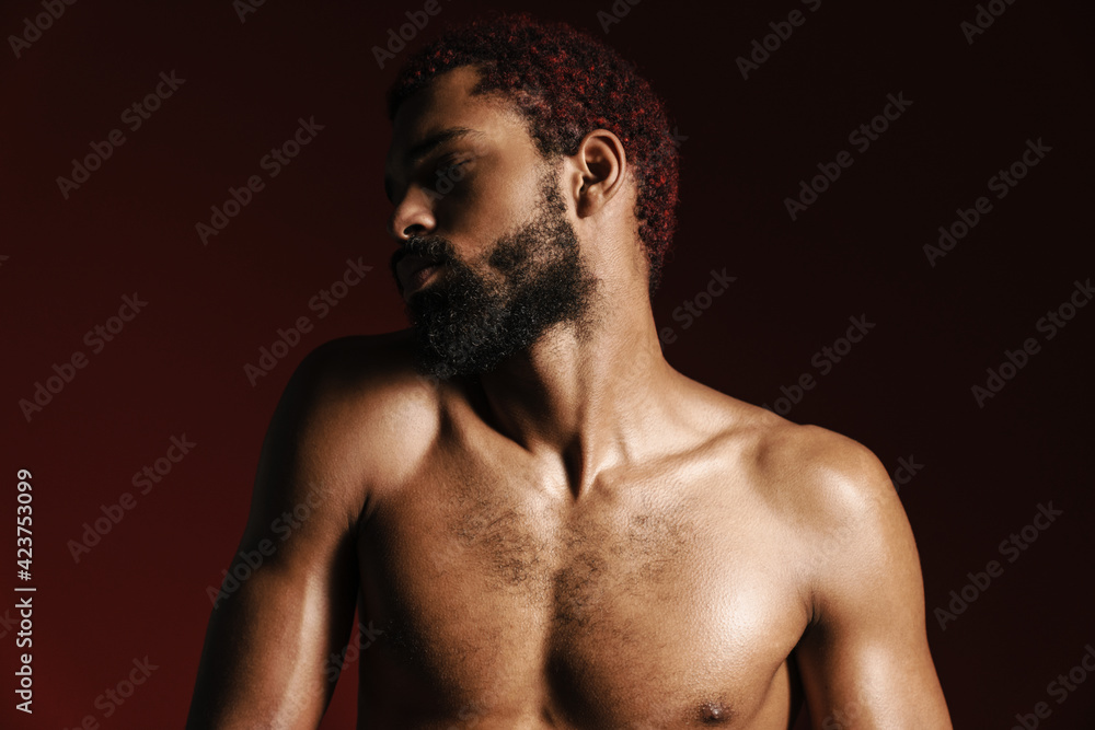 Fototapeta premium Black shirtless bearded man posing and looking aside