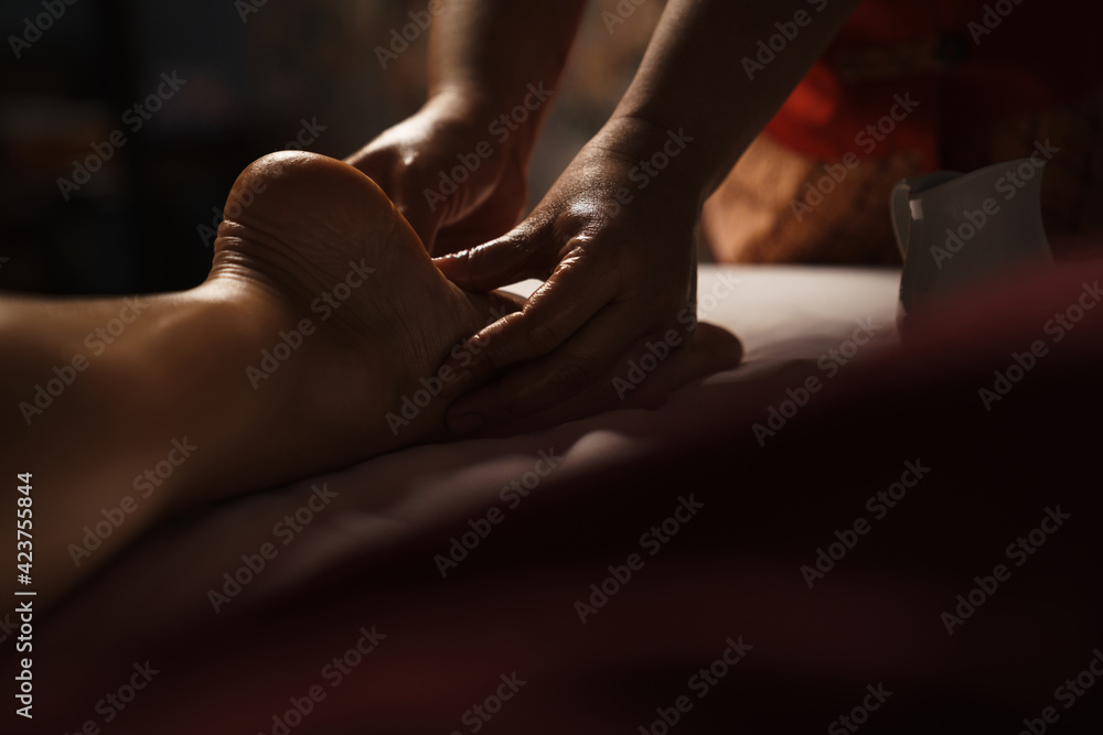 Professional masseuse doing foot massage with oil in spa Professional masseuse doing foot massage with oil in spa
