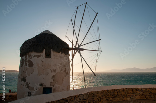 Close-up of an old windmill on the island of Mykonos at sunset in Greece. In the background the sky and the Mediterranean sea.