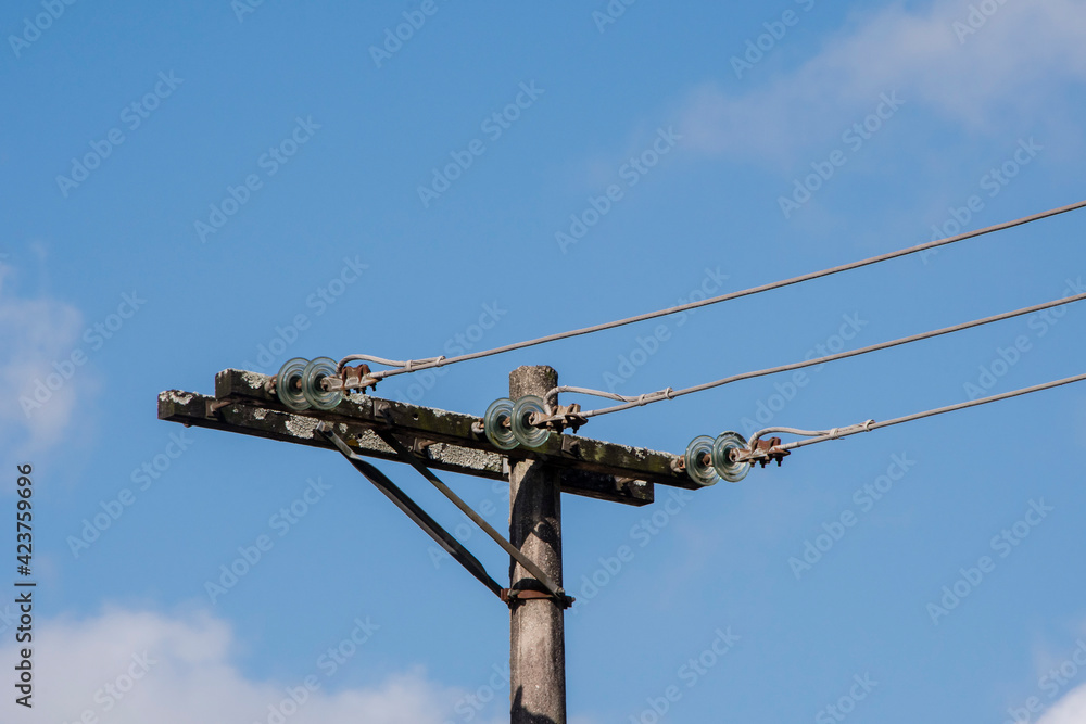 Old electricity distribution pole. Blue sky background. Old electricity distribution pole. Blue sky background.