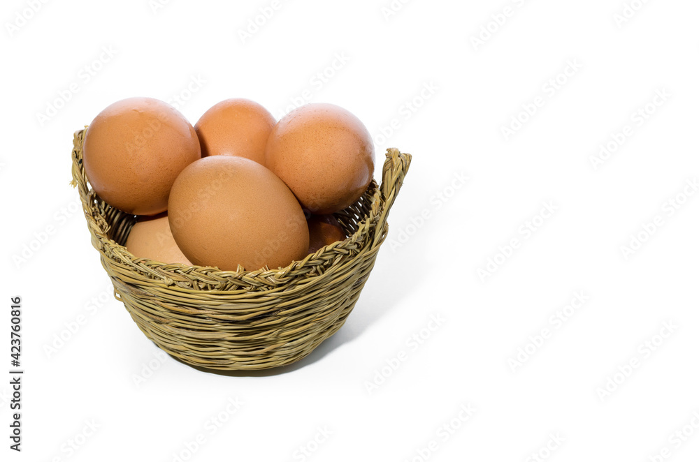 Fresh eggs inside a wicker basket on white background. Copy space Fresh eggs inside a wicker basket on white background. Copy space