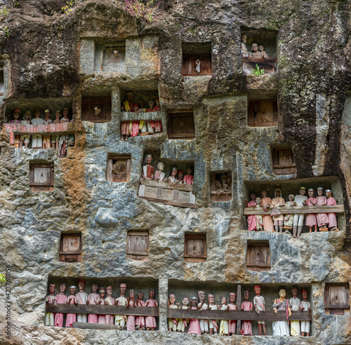 Rock tombs and galleries of Tau Tau in the steep rock face of the burial site of Lemo in Tana Toraja on Sulawesi. The Tau Tau symbolize the continuation of the life of the deceased in the afterlife