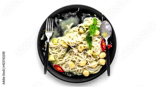 Rice noodles with green curry meatballs on white background