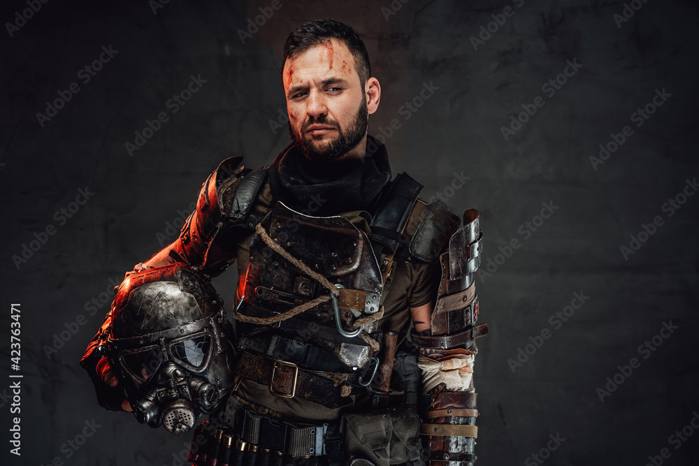 Fototapeta premium Bearded apocalyptic survivor with helmet in dark background
