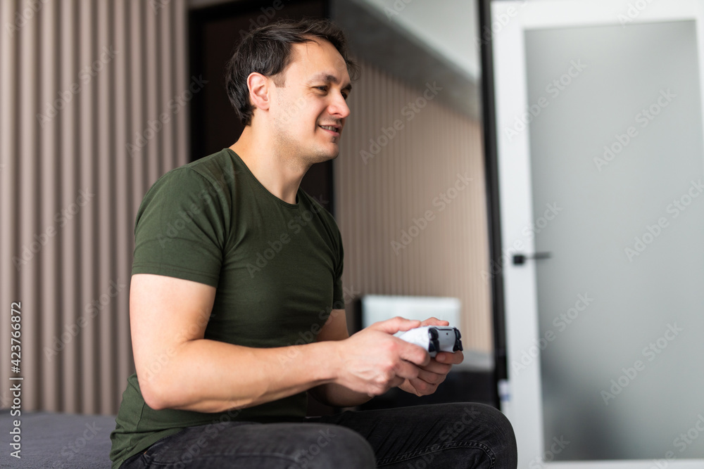 Excited young man playing video game on sofa Excited young man playing video game on sofa