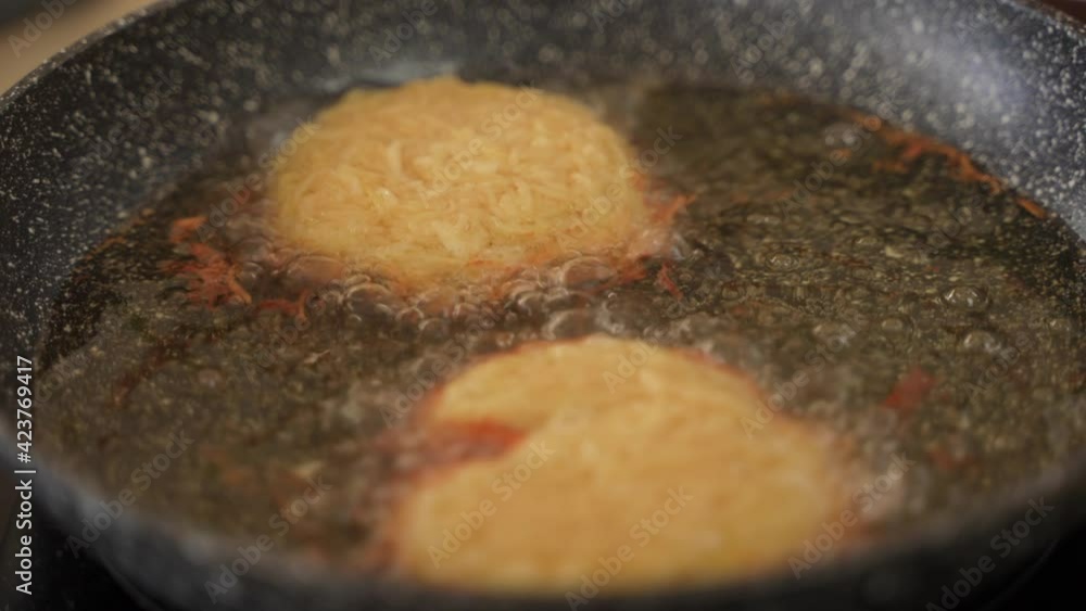 Close-up of frying fresh homemade hashbrown potato puffs in oil. Close-up of frying fresh homemade hashbrown potato puffs in oil.